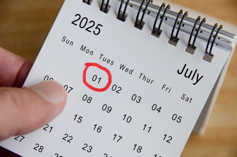 Close up view of July 2025 Calendar on wooden desk background. Monthly calendar concept