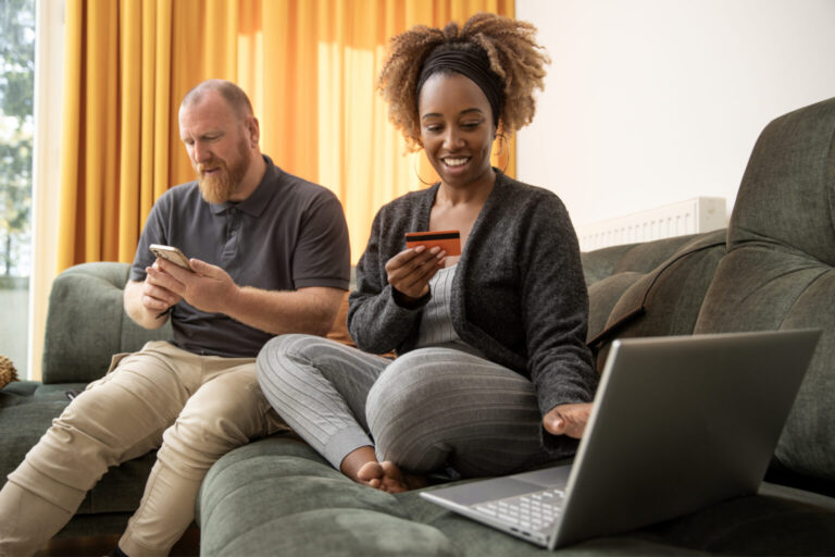 Mixed race couple working on personal finance on the sofa at home